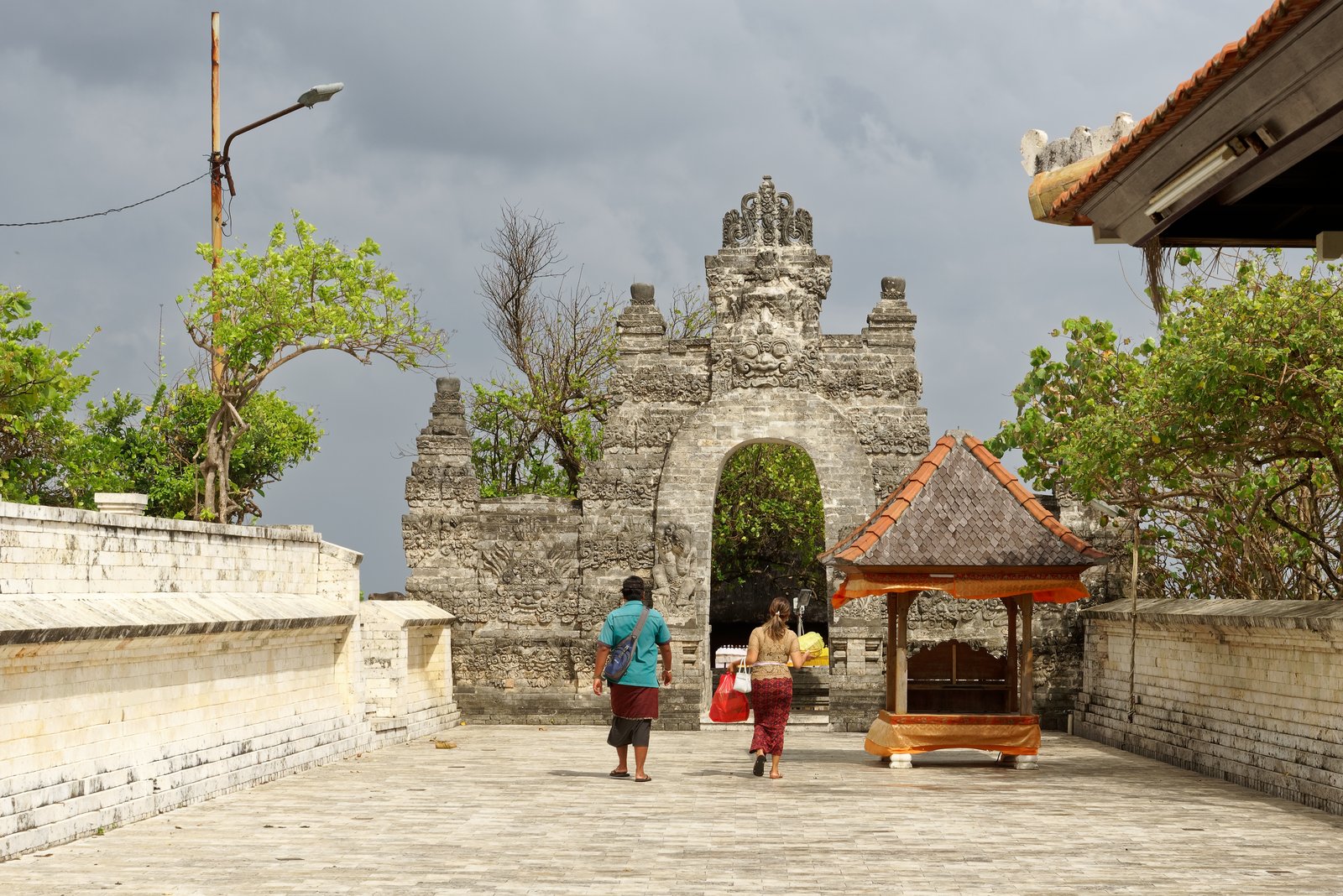 Porte fendue du temple d'Uluwatu avec des visiteurs en sarong